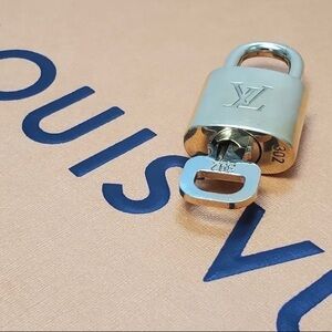 NEAR MINT Louis Vuitton lock and key set.